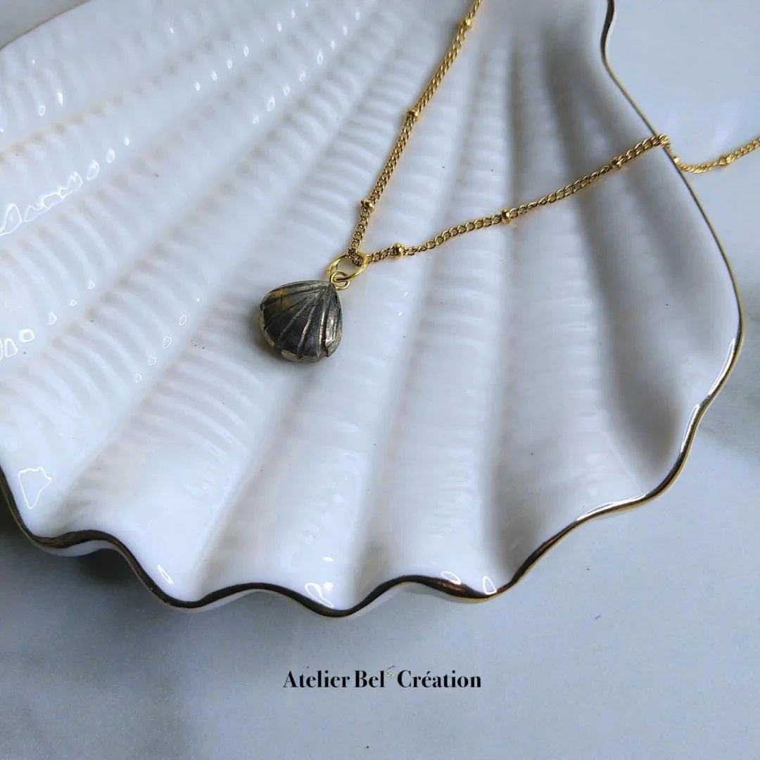 Pendentif en Pyrite naturelle en forme de coquillage aux reflets métalliques dorés.